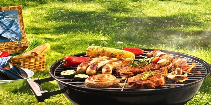 People enjoying a picnic in Dubai park with green lawns, trees, and city skyline