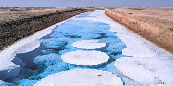 Al Wathba Salt Lake in Abu Dhabi showing emerald water and white salt flats with desert background