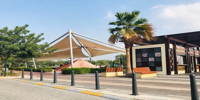 Green lawns and playground at Delma Park Abu Dhabi with walking trails and shaded trees