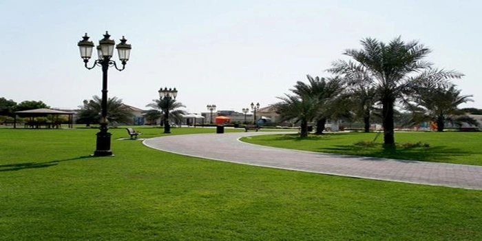Hamidiya Park Ajman with green lawns, kids playground, walking tracks, and shaded benches