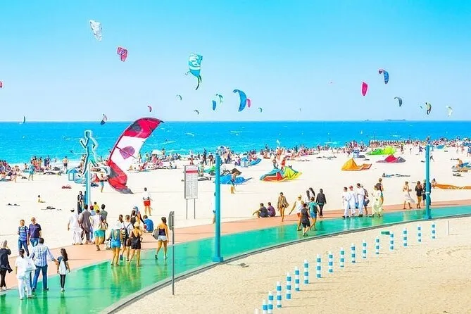 People enjoying themselves on the shore at Kite Beach Dubai, flying colorful kites and relaxing in the sun