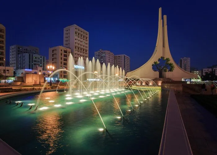 Rolla Park Sharjah with children playing in the playground and fountains in the background