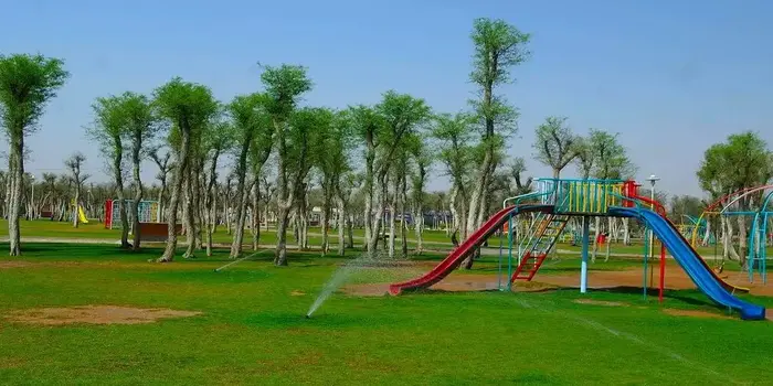 Saqr Park Ras Al Khaimah showing families enjoying a picnic, lake, playground, and green gardens